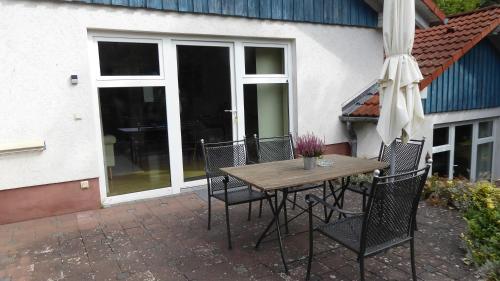 a table and chairs with an umbrella on a patio at Landleben - Ferienhaus 1 in Fritzlar