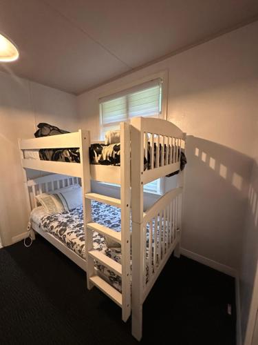 a bedroom with two bunk beds and a window at Basic, Super 'Cosy' Cabin in The Middle of National Park and Mountains in Otira