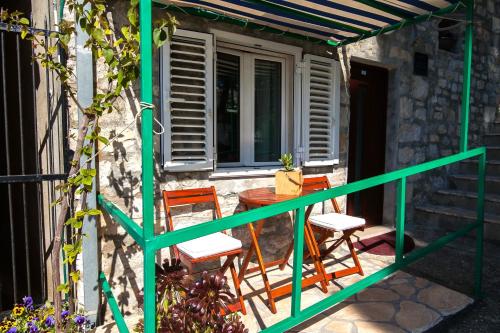 einen Balkon mit einem Tisch und Stühlen sowie einem Fenster in der Unterkunft Old Town Accommodation in Bol