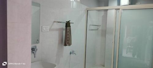 ein Bad mit einer Dusche und einem Handtuch auf einer Stange in der Unterkunft Newa House Homestay in Shiliguri