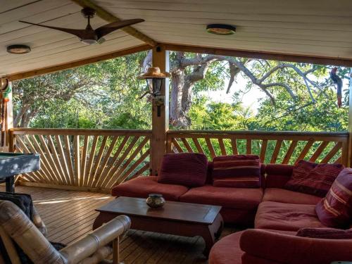 a screened in porch with a couch and a table at Freedomhome974 in Le Tampon