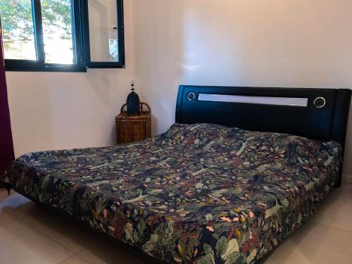 um quarto com uma cama com um edredão colorido em Freedomhome974 em Le Tampon