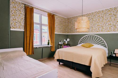 1 dormitorio con 2 camas y ventana en Idyllinen huvikumpu Vanhan Rauman ytimessä, In the heart of Old Rauma en Rauma