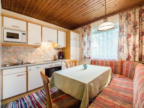 クライナルにあるAppealing Apartment in Kleinarl with Ski Storageのキッチン(テーブル付)、キッチン(電子レンジ付)