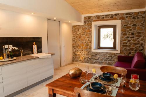 a kitchen and living room with a wooden table and a counter at Casa Feraxi at Casa Sardinia in Muravera