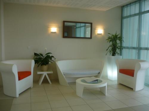 a living room with two chairs and a couch and a table at Résidence Goélia La Grande Plage in Saint-Gilles-Croix-de-Vie