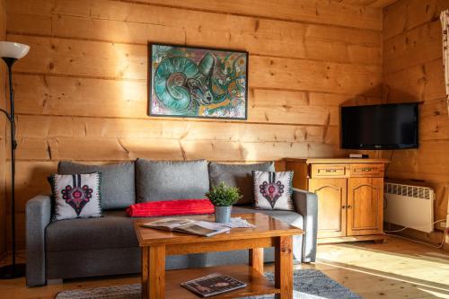 a living room with a couch and a table at Osada Kościelisko - Tatry na Wyciągnięcie Ręki in Kościelisko