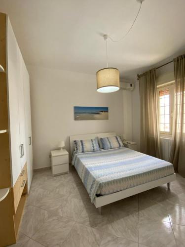 a bedroom with a bed and a pendant light at Casa Linda in Porto Cesareo