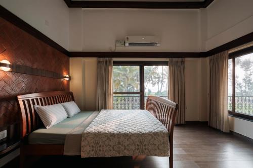 1 dormitorio con cama y ventana grande en Tatasth Beach Villa, en Kundapur