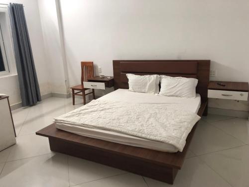 een slaapkamer met een groot bed met witte lakens en kussens bij Kiều Thủy Hotel in Bao Loc