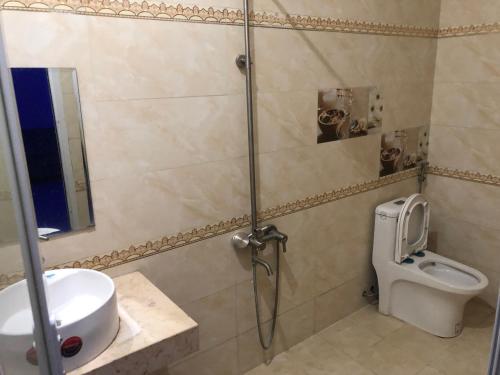een badkamer met een douche, een wastafel en een toilet bij Kiều Thủy Hotel in Bao Loc