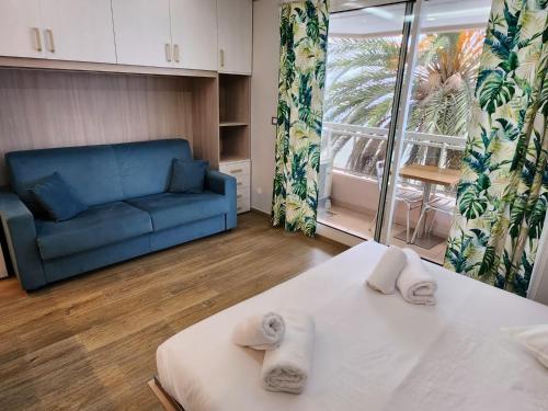 a living room with a blue couch and a bed at Bluemarine, studio vista Mare in Menton