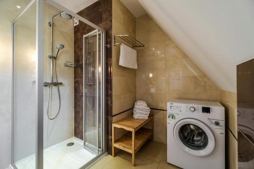 a bathroom with a washing machine and a shower at Osada Kościelisko - Tatry na Wyciągnięcie Ręki in Kościelisko