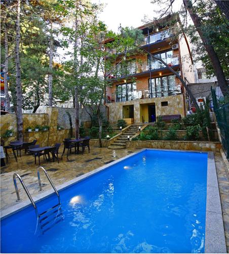 a large blue swimming pool in front of a building at Sani Hotel in Tbilisi City