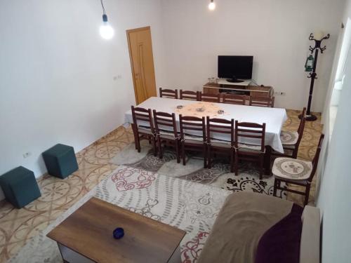 a dining room with a table and chairs and a television at Bujtina Aliaj in Tropojë