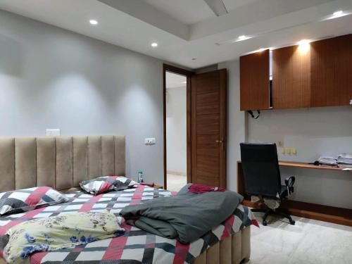 a bedroom with two beds and a desk and a chair at The LUTF in New Delhi