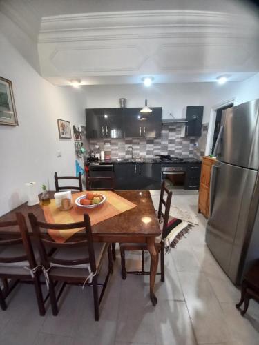 a kitchen with a table and a stainless steel refrigerator at Appartement Cerine 1 , nur 100 Meter bis Tantana Strand in Port El Kantaoui