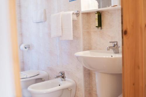 a bathroom with a sink and a toilet at Residence Al Caminetto in Molveno