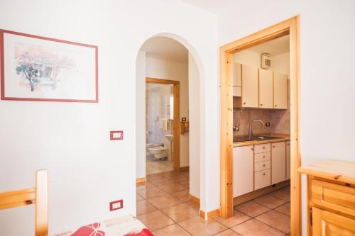 a kitchen with white cabinets and a sink at Residence Al Caminetto in Molveno