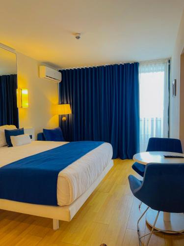 a hotel room with a bed and a desk and a table at Batumi High View in Batumi