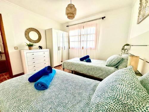 a bedroom with two beds with blue towels on them at Vista Mar 1241 in Puerto del Carmen