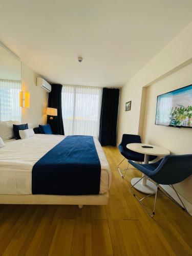 a hotel room with a bed and a table and chairs at Batumi High View in Batumi