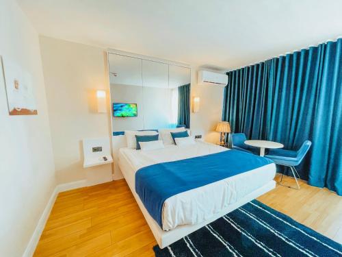 Batumi High View في باتومي: غرفة نوم بسرير كبير وستائر زرقاء