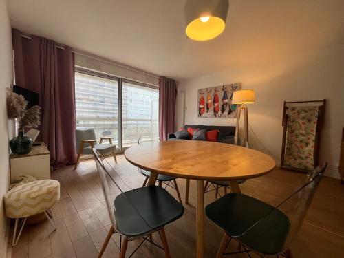 un salon avec une table et des chaises en bois dans l'établissement CorailB12, à Le Touquet-Paris-Plage