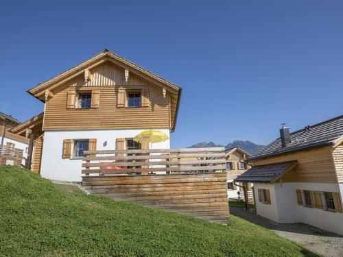 a house with a wooden fence in front of it at Cozy Chalet in Wei priach with Terrace in Weisspriach