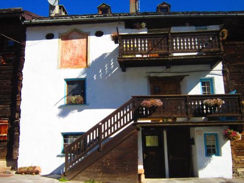 Edificio blanco con escalera y balcón en canton 520 camera matrimoniale e appartamento self check in, en Livigno