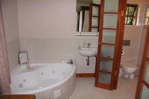 a bathroom with a tub and a sink and a toilet at Oakhampton Bed and Breakfast in East London