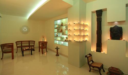 a room with chairs and tables and a shelf with lights at Vythiri Village in Vythiri