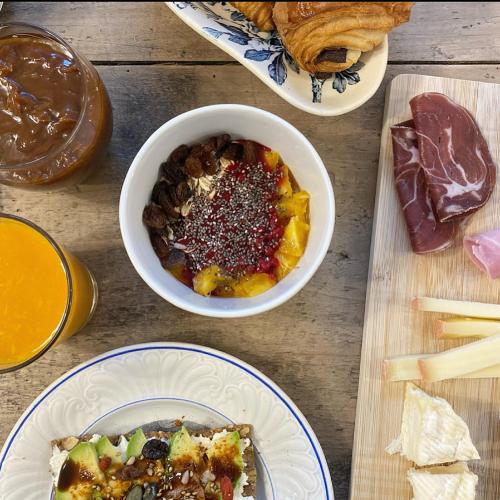 a table with plates of food and a bowl of food at Maison Galop Marin in Saint-Côme-du-Mont