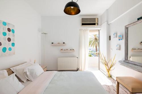 a white bedroom with a large bed and a window at Seaside Haven Central Marina Nearby Parking in Agios Nikolaos