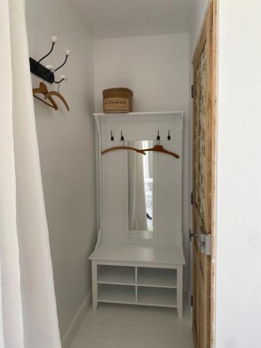 a white dressing table with a mirror in a room at Maison Galop Marin in Saint-Côme-du-Mont