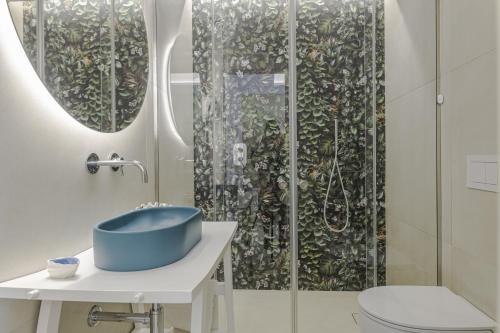 a bathroom with a blue sink and a shower at Le Gemelle Boutique Hotel in Torre Suda