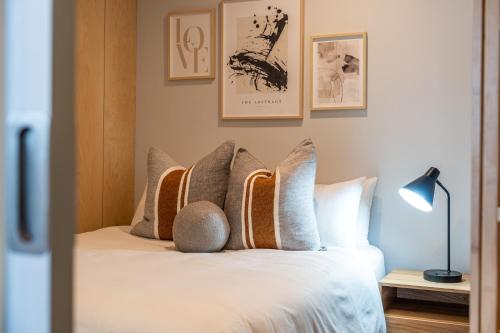 een slaapkamer met een bed met bruine en witte kussens bij Paradiso on Bent Adelaide in Adelaide