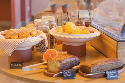 a table with various types of bread and other foods at Le Saint Erasme, Hotel Eco Friendly in Calvi