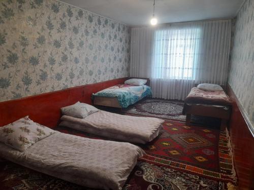 a room with three beds and a couch at Xinaliq BedBreakfast in Quba