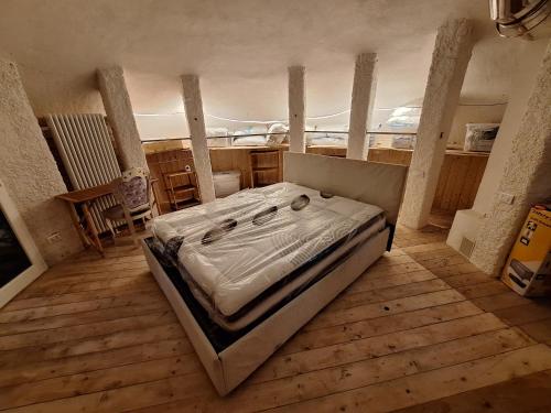 BardinetoにあるIl villaggio dei puffiのウッドフロアの客室で、大型ベッド1台を利用できます。