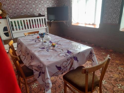 a dining table with a white table cloth and chairs at Xinaliq BedBreakfast in Quba