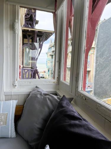 un oreiller assis dans une fenêtre avec vue dans l'établissement Appartement Cosy Villa Française, à Mers-les-Bains