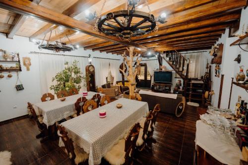 a dining room with tables and chairs and a chandelier at Cabana Paradisul Verde Neamt in Târgu Neamț