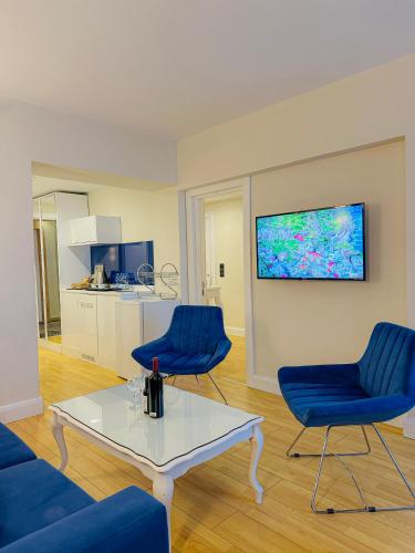a living room with two blue chairs and a table at Batumi High View in Batumi