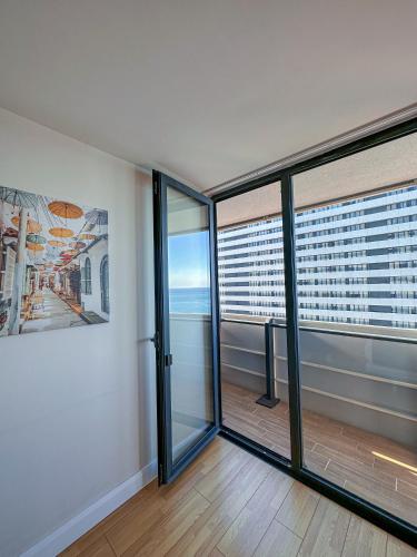 a room with glass doors and a view of the city at Batumi High View in Batumi