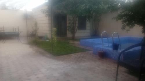 a backyard with a swimming pool in the rain at Чавандоz in Yakkasaray