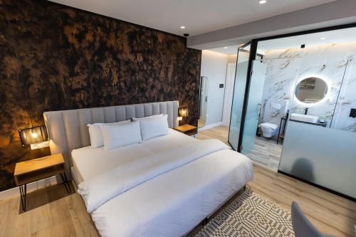 a bedroom with a large white bed and a wall at Vila Kace in Korçë