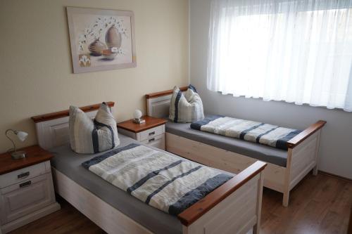2 camas en una habitación con ventana en Ferienhaus Vorwachs 4 EG en Schwielochsee