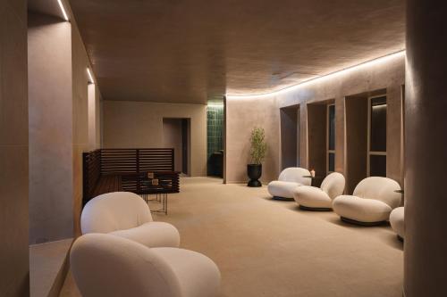 a hallway with white chairs in a building at Enter St Elisabeth Suites & Spa in Tromsø