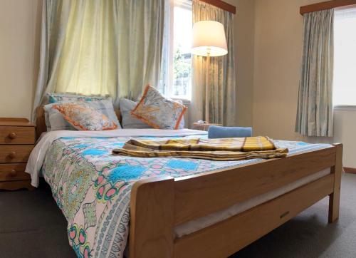 a bedroom with a bed with a blanket on it at Rest & Relax Villa Whangarei in Whangarei